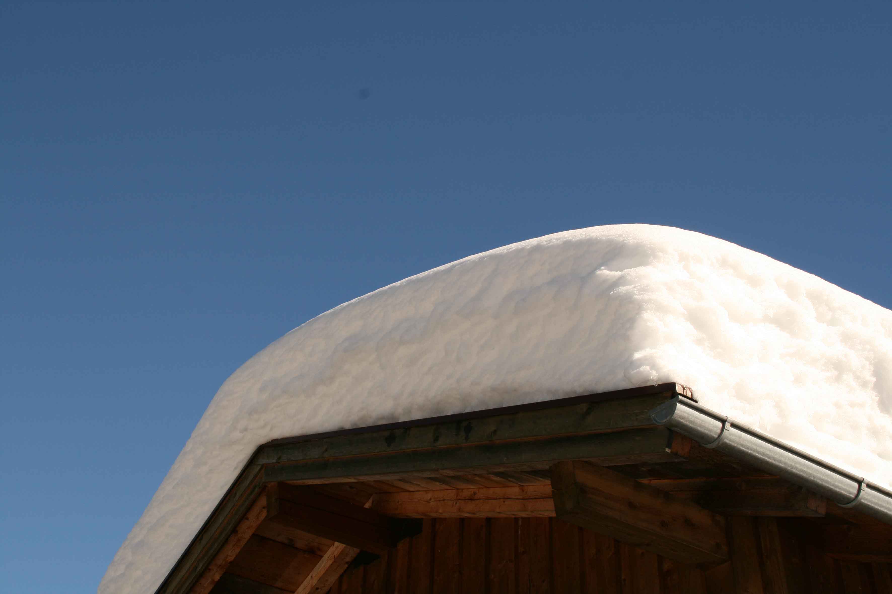 Eine dicke Schneedecke lastet auf diesem Dach. Eine dicke Schneedecke lastet auf diesem Dach.