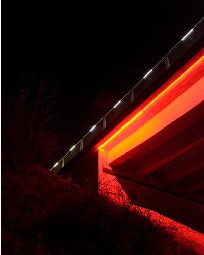 Bauwerk bei Nacht - Bei Nacht verwandelt sich der Fischbauch aus grauem Beton in ein feuriges Rot. Feine Lichtstriche aus dem Handlauf des Gel�nders leuchten beide Gehwegseiten fl�chig aus